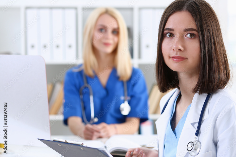 Beautiful smiling female doctor stand in office Beautiful smiling female doctor stand in office