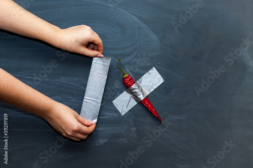 Red pepper duct taped to the chalkboard. Modern art