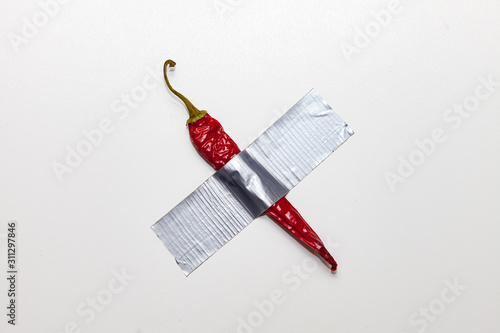 Red pepper duct taped to the white wall. Conceptual photo. Modern art photo