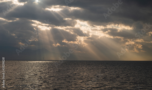 Lights falling into the city among the clouds. Dance of lights in Izmir Bay. ...