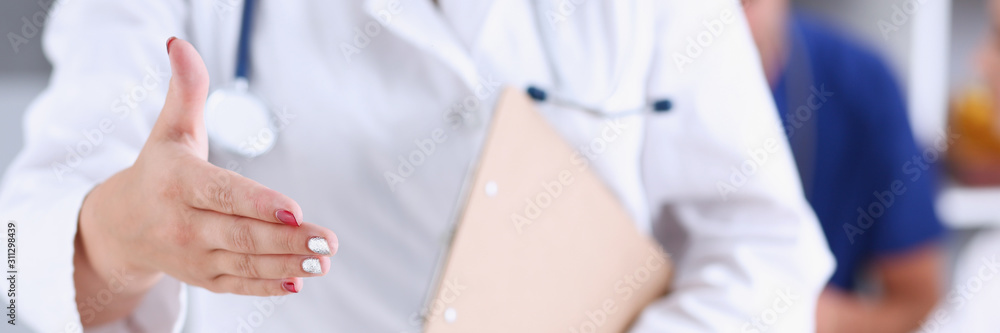 Female medicine doctor hold pad and give arm to shake Female medicine doctor hold pad and give arm to shake