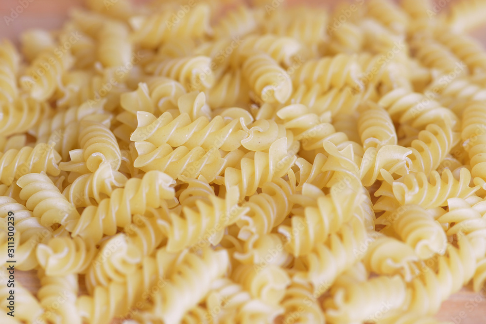 Scattered macaroni on a wooden surface close-up. Food background Scattered macaroni on a wooden surface close-up. Food background