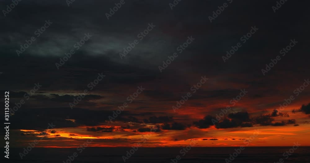 Ocean panorama. Dark orange clouds day to night sky. Dramatic sunset over storm clouds. Beautiful red color sky. Red purple orange blue pink sunset cloud background. Concept holiday in the tropics. Ocean panorama. Dark orange clouds day to night sky. Dramatic sunset over storm clouds. Beautiful red color sky. Red purple orange blue pink sunset cloud background. Concept holiday in the tropics.