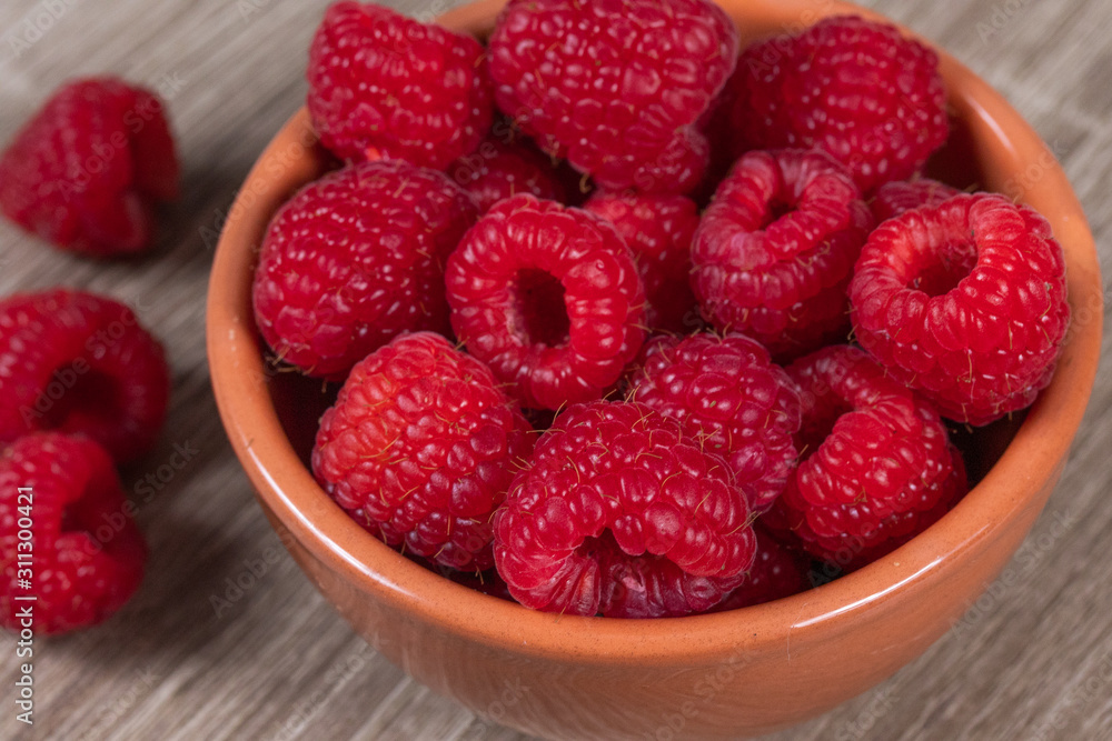 dish of fresh raspberries on a table dish of fresh raspberries on a table