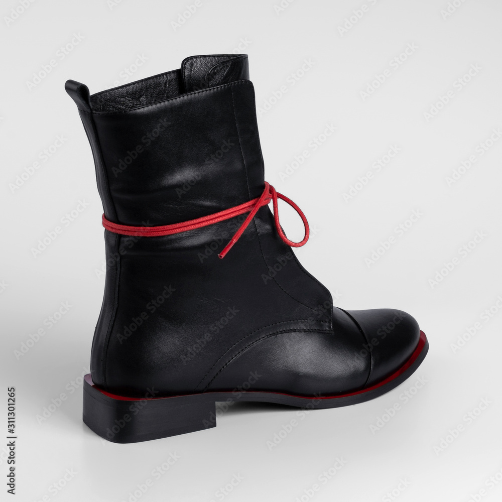 high black womens leather boots demi season on a flat sole with red lacing. Studio photo for catalog, close-up high black womens leather boots demi season on a flat sole with red lacing. Studio photo for catalog, close-up