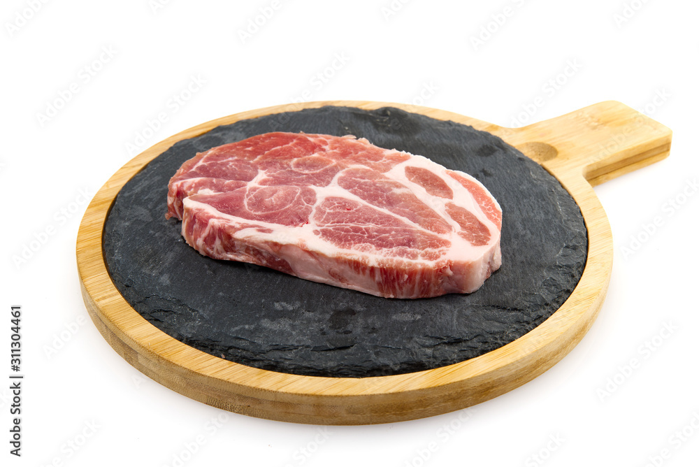 raw pork steak on black stone and wood. Pork with spices: rosemary and pepper. Close-up raw pork steaks. raw pork steak on black stone and wood. Pork with spices: rosemary and pepper. Close-up raw pork steaks.