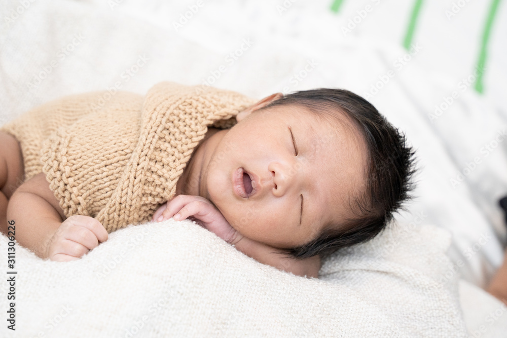 Happy cute adorable Asian baby boy with black hair lying a white blanket. Happy cute adorable Asian baby boy with black hair lying a white blanket.