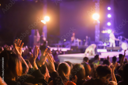 Defocused Abstract Live concert with raising hands. Silhouettes of concert crowd in front