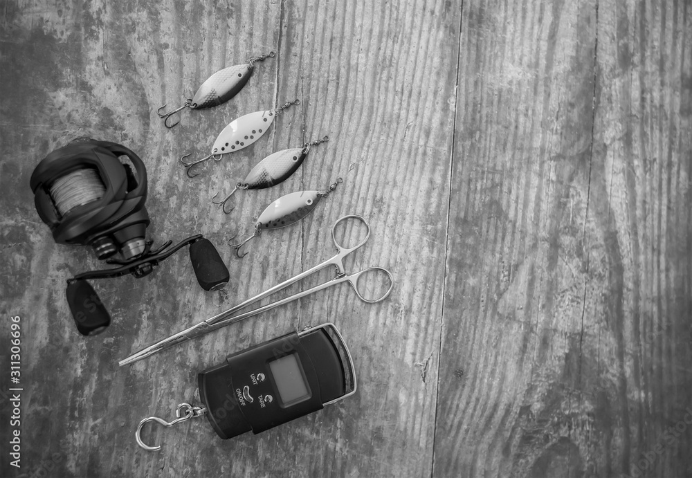 Flat lay of lure fishing tackle on a plain wooden background with copy space