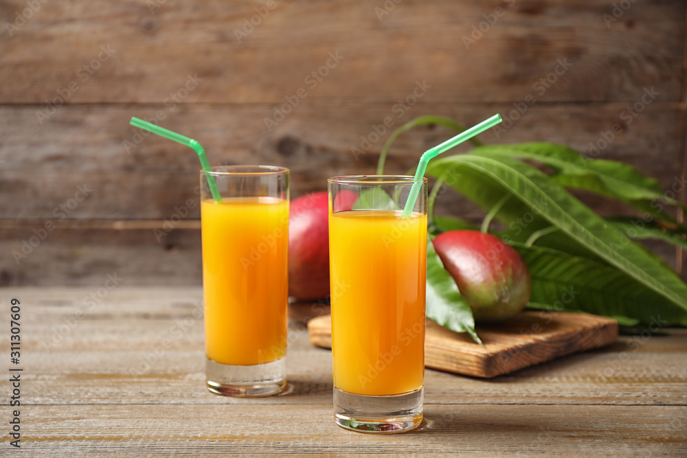 Fresh delicious mango drink on wooden table Fresh delicious mango drink on wooden table