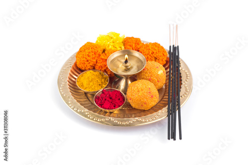 Beautifully Decorated Pooja Thali for festival celebration to worship, haldi or turmeric powder and kumkum, flowers, scented sticks in brass plate, hindu puja thali photo