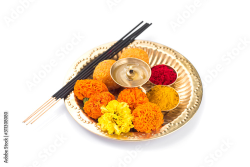 Beautifully Decorated Pooja Thali for festival celebration to worship, haldi or turmeric powder and kumkum, flowers, scented sticks in brass plate, hindu puja thali photo