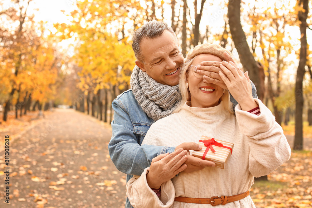 Naklejka premium Mature man greeting his wife in autumn park