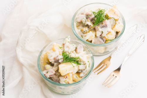Salad rasols made of herring, cucumber and potato, dressed with mayonnaise and mustard photo