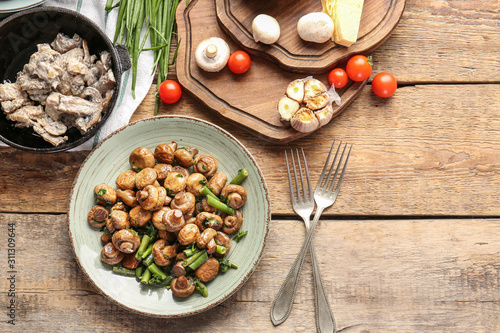 Tasty cooked mushrooms on table