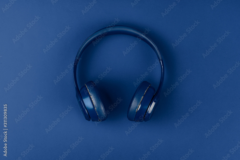 Blue headphones on blue background, top view Blue headphones on blue background, top view