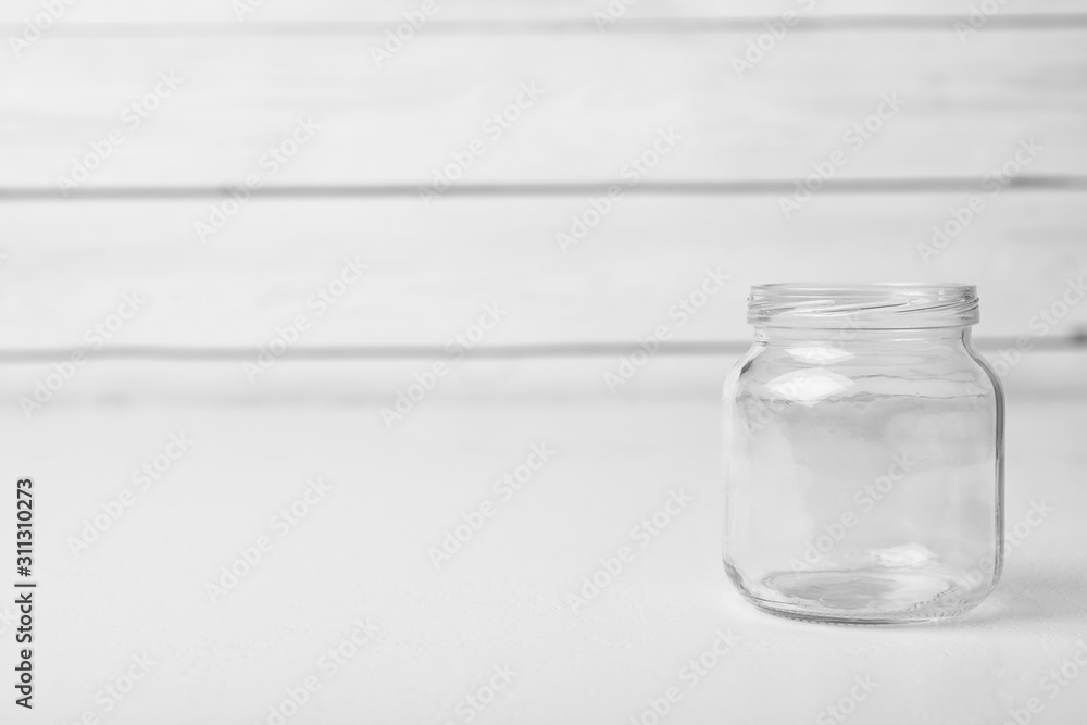 Empty glass jar on white table, space for text Empty glass jar on white table, space for text