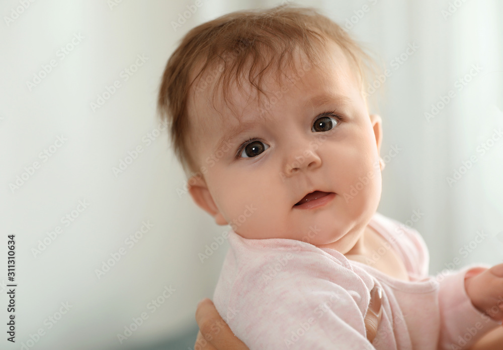 Young woman with her cute baby at home, closeup