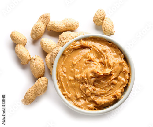 Tasty peanut butter in bowl on white background