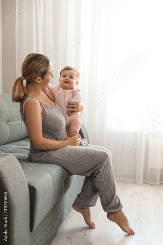 Young woman with her cute baby at home