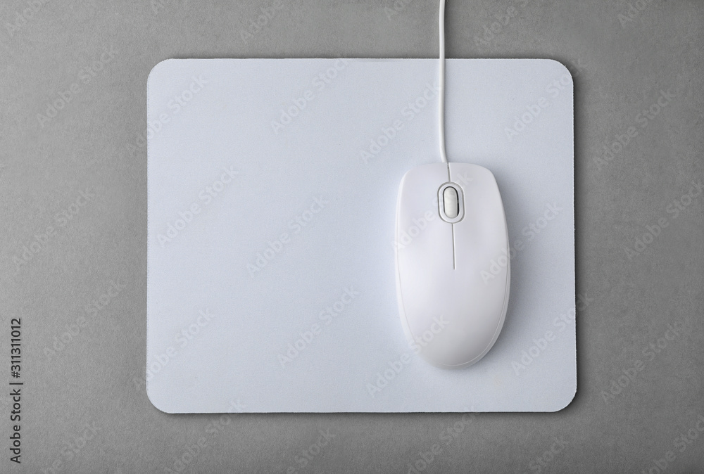 Wired computer mouse and pad on grey background, flat lay Wired computer mouse and pad on grey background, flat lay