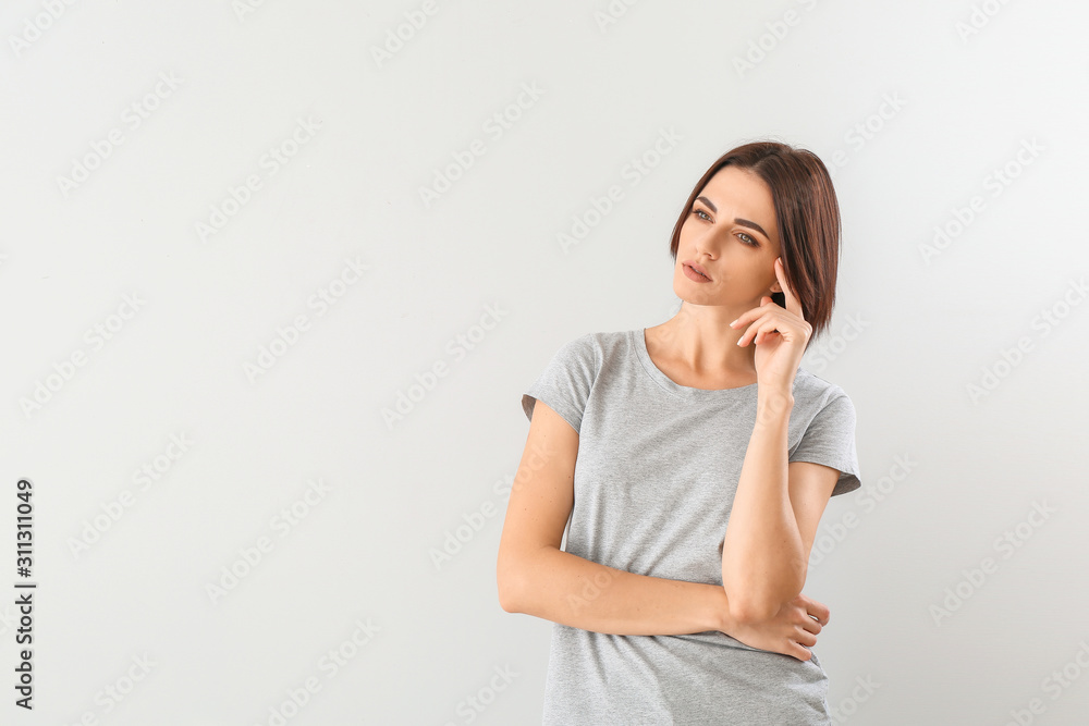 Beautiful thoughtful young woman on grey background Beautiful thoughtful young woman on grey background