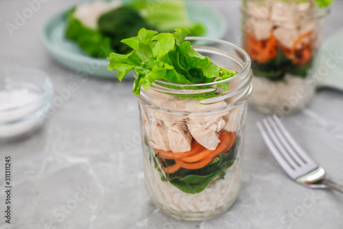Healthy salad in glass jar on marble table