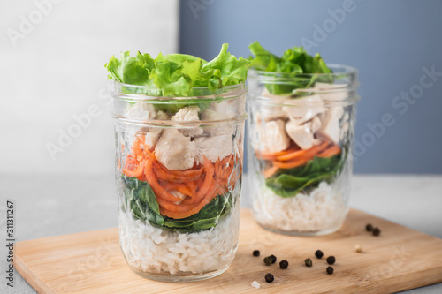Healthy salad in glass jars on light table