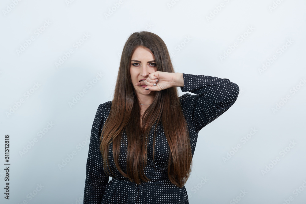 Charming caucasian woman over isolated gray background wearing casual black dress with white polka dot, bites her finger, looking at camera. People lifestyle concepte. Charming caucasian woman over isolated gray background wearing casual black dress with white polka dot, bites her finger, looking at camera. People lifestyle concepte.