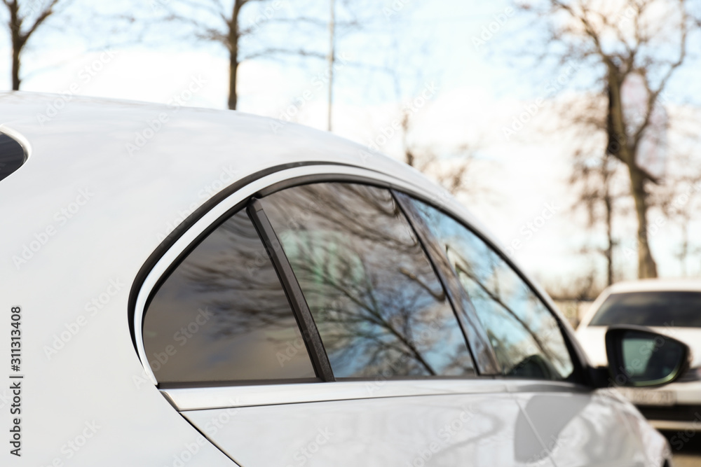 Modern car with tinting foil on window outdoors, closeup