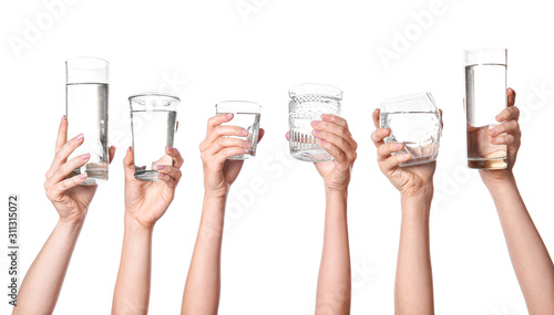 Obraz na płótnie Female hands with glasses of water on white background