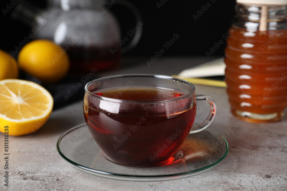 Fresh tea with honey and lemon on light grey table, closeup Fresh tea with honey and lemon on light grey table, closeup