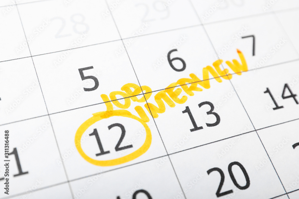 Calendar with date reminder about job interview, closeup Calendar with date reminder about job interview, closeup