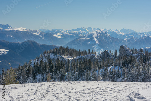 Fototapeta Naklejka Na Ścianę i Meble -  Schnee in den Bergen, Fußspuren und Bäume