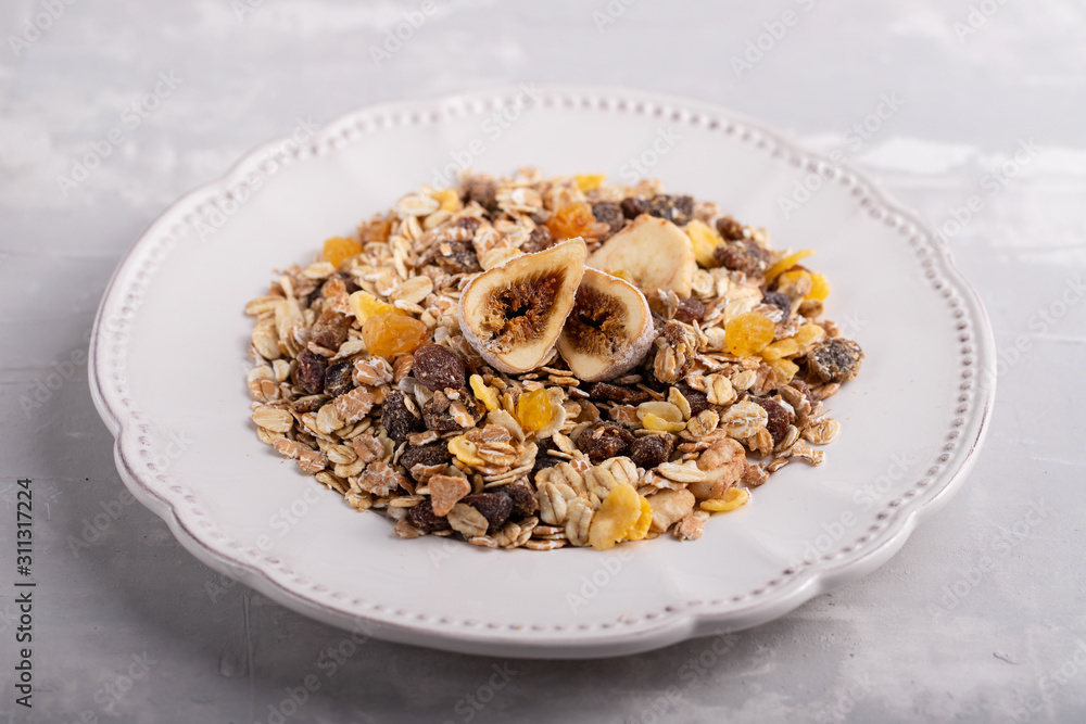 muesli with nuts and dry figs on dish on ceramic background muesli with nuts and dry figs on dish on ceramic background