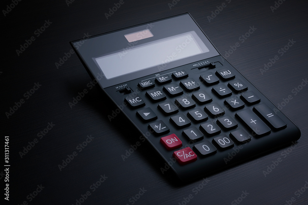 Side view of a black accounting calculator with a blank display on a dark wooden table with copy space for text. Calculation of taxes, payments and profits concept Side view of a black accounting calculator with a blank display on a dark wooden table with copy space for text. Calculation of taxes, payments and profits concept