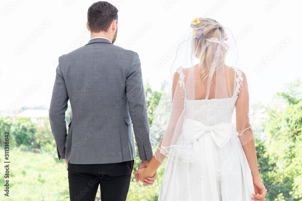 Bride and groom couple of Caucasian smile and standing together hand in hand. Bride and groom couple of Caucasian smile and standing together hand in hand.