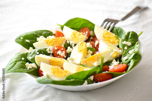 Egg salad with spinach, cherry tomatoes and feta cheese. The concept of healthy food, dietary and weight loss plan. 