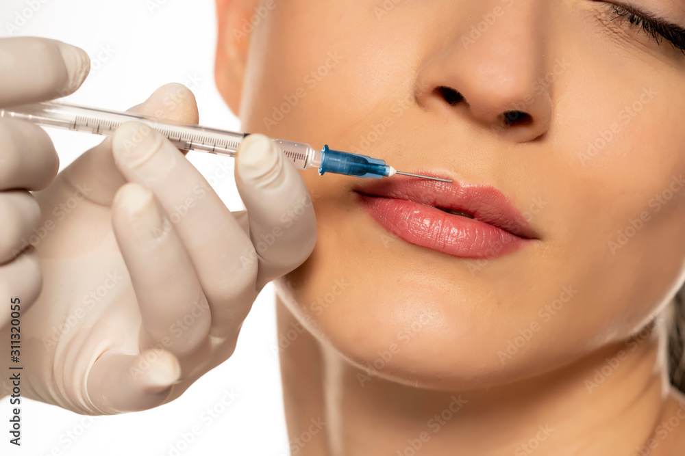 Portrait of a young beautiful woman on a botox injection procedure on white background Portrait of a young beautiful woman on a botox injection procedure on white background