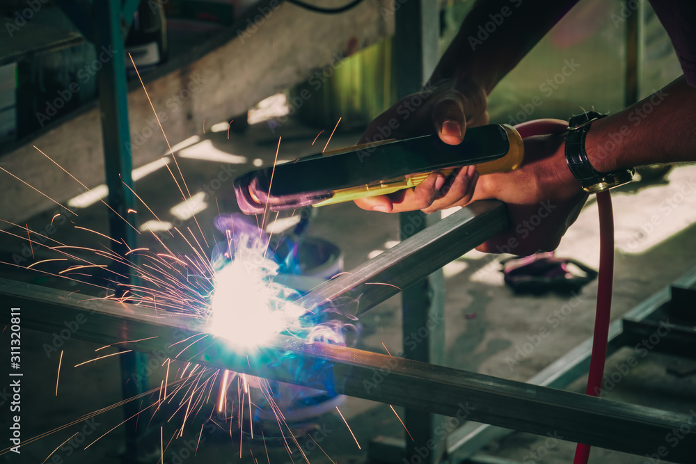 Fototapeta premium Industrial Worker labourer at the factory welding steel structure, Welder at work