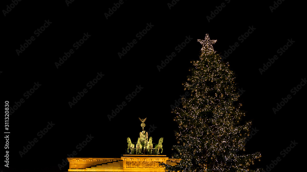 Illuminated Neoclassical Brandenburg Gate (Brandenburger Tor) and Christmas Tree in the year 2019 as viewed from the Pariser Platz, Berlin, Germany
