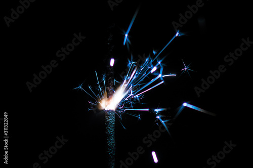 Sparkler in blue and white light on a black background