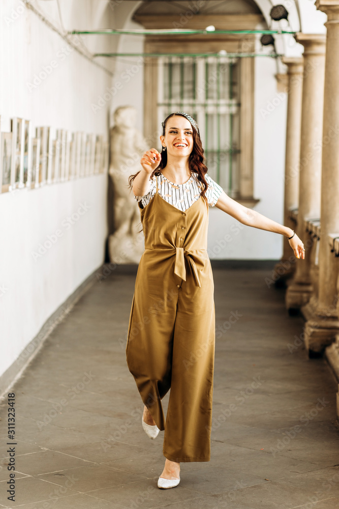 Fototapeta premium Beautiful girl dancing in the hall of the photo exhibition