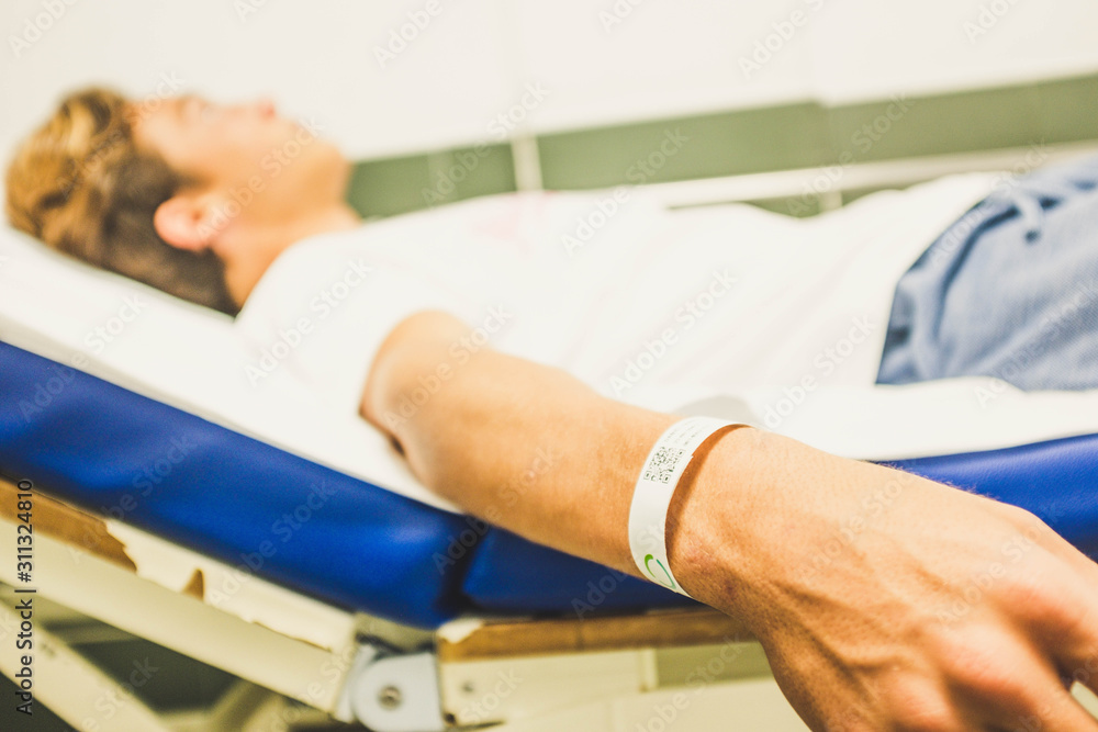 Obraz premium one teenager lying on the bed of the hospital - sick man waiting at the doctor alone