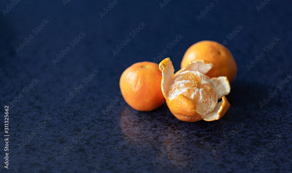 Obraz premium Mandarin oranges closeup on dark background, riped mandarine orange