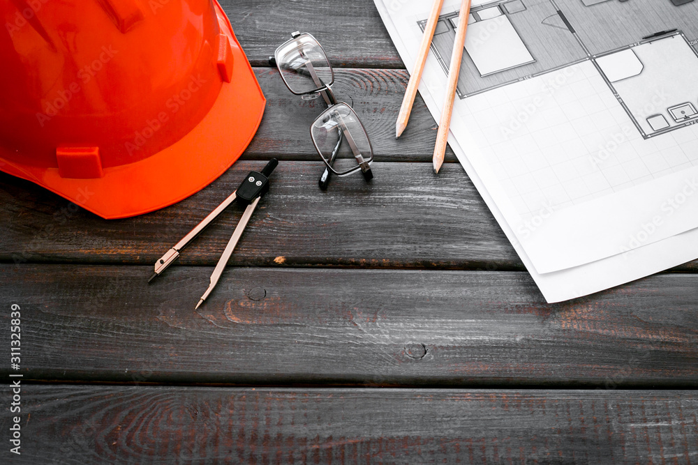 Construction concept. Helmet and blueprints on dark wooden background copy space Construction concept. Helmet and blueprints on dark wooden background copy space