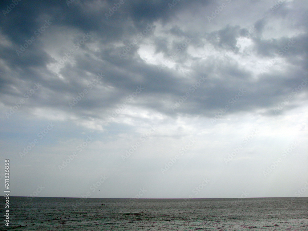 A view from the seashore on the celestial picture of the autumn clouds that surround the dense ring and hide the still hot sun. A view from the seashore on the celestial picture of the autumn clouds that surround the dense ring and hide the still hot sun.