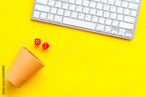 Hazard gemes online concept. Dices near keyboard on yellow background top-down copy space