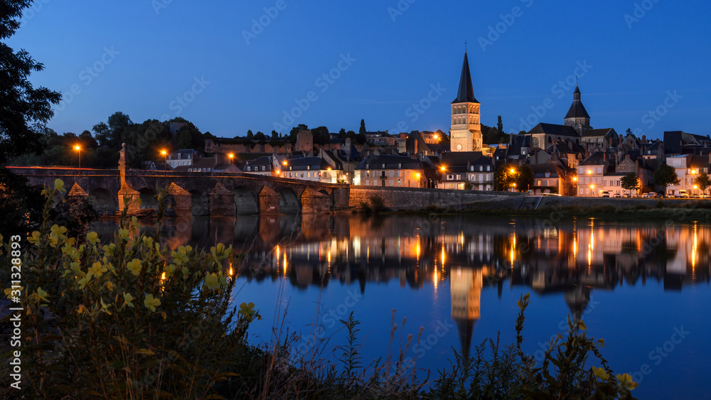 La Charité sur Loire, a typical french village in Burgundy (FRANCE) reflecting on the river Loire at the blue hour.