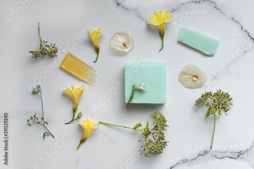organic natural blue soap for spa or body care with wild yellow flower on marble stone background